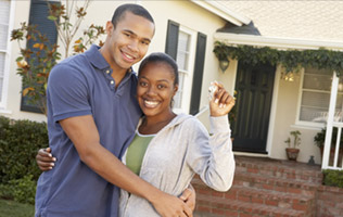 happy couple in front of their new house