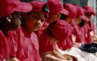 boys lined up on a baseball bench